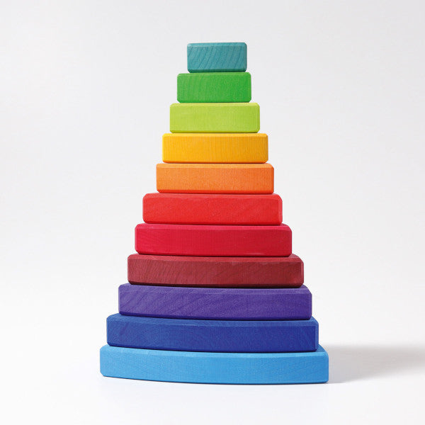 Wooden triangles in rainbow colours are stacked on top of each other in size order
