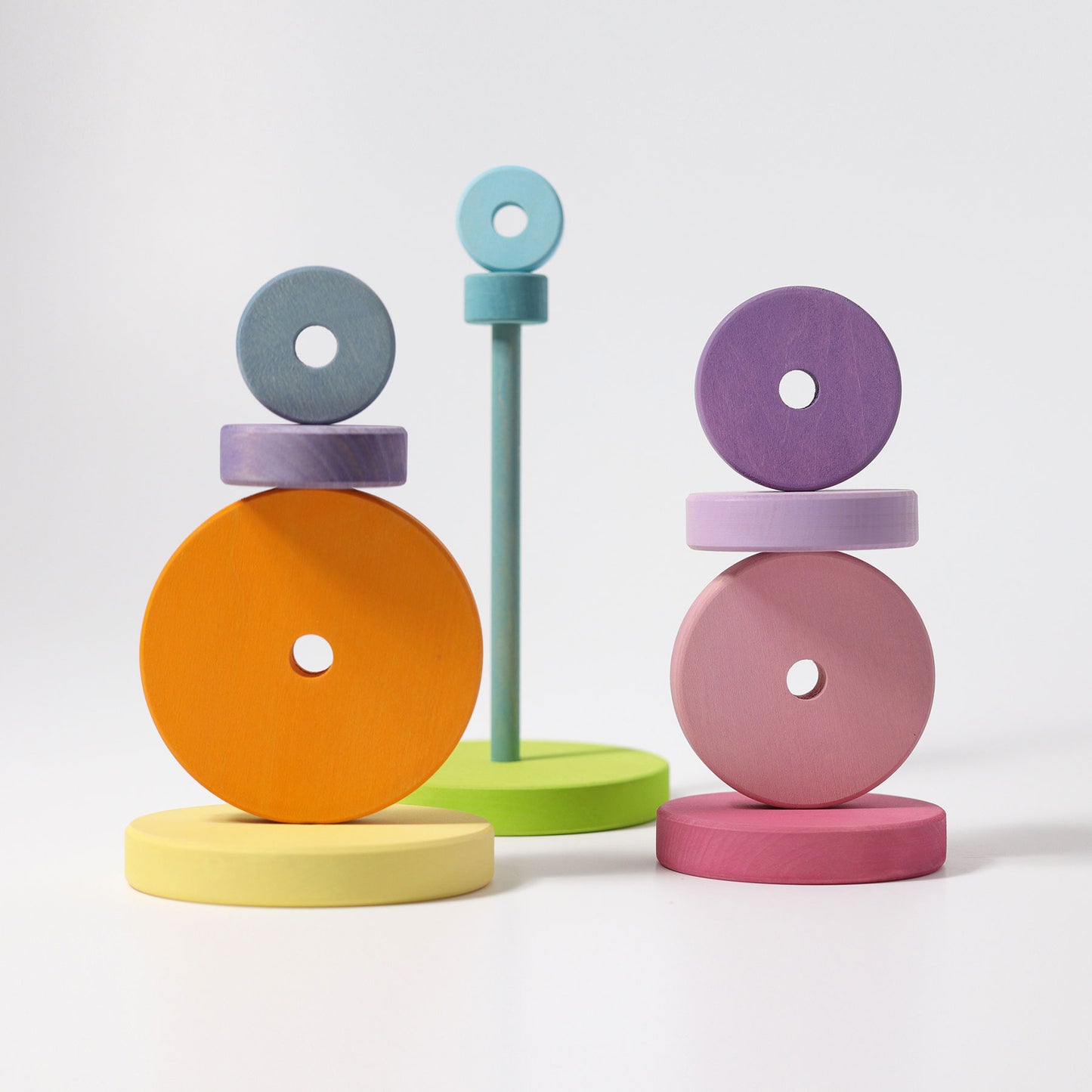 Multiple wooden circle discs are stacked and balanced in various towers