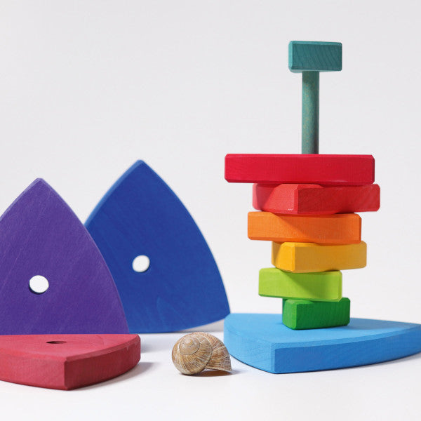 various triangular pieces of a childs stacking toy in rainbow colours