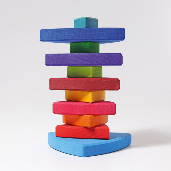 various rainbow coloured pieces of wood are stacked on top of each other