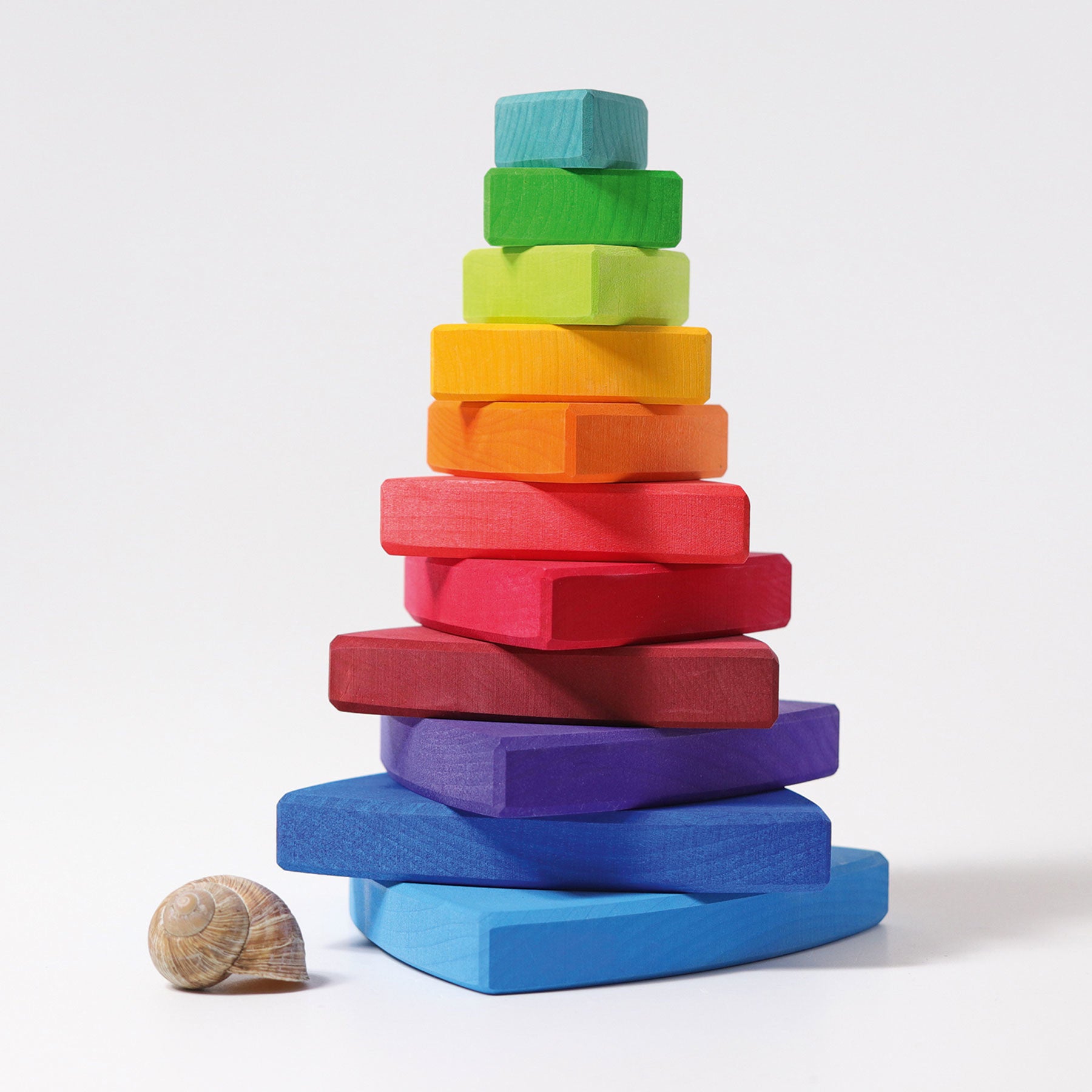 various rainbow coloured wooden pieces are stacked on top of each other