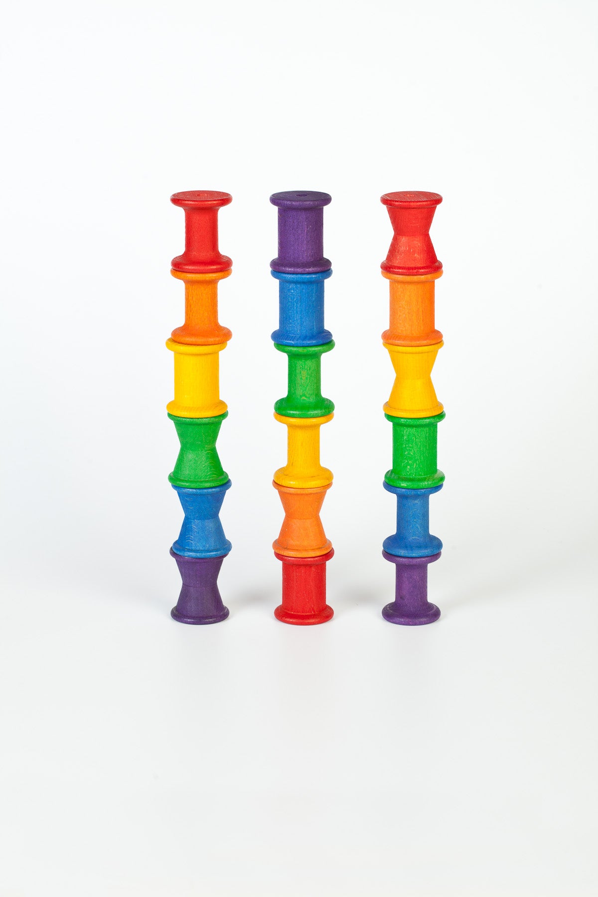 Wooden rainbow spools stacked in three columns